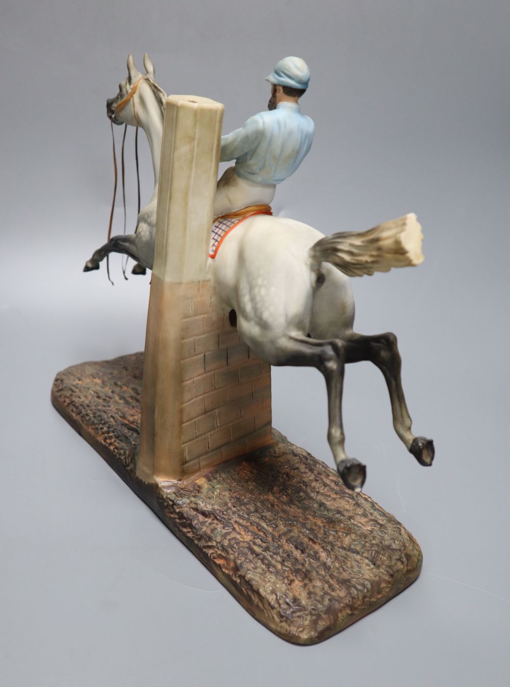 A cast coloured bisque porcelain horse and jockey group, height 26cm